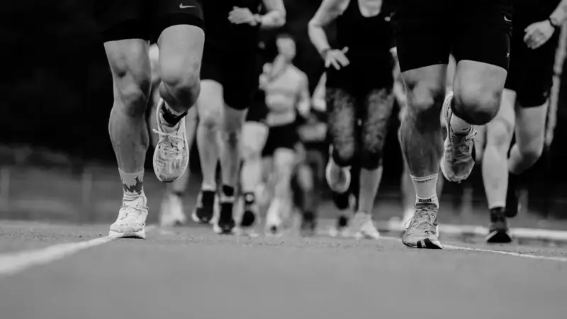 Atlete hardloop op die baan tydens 'n Deadly Dozen-wedloop