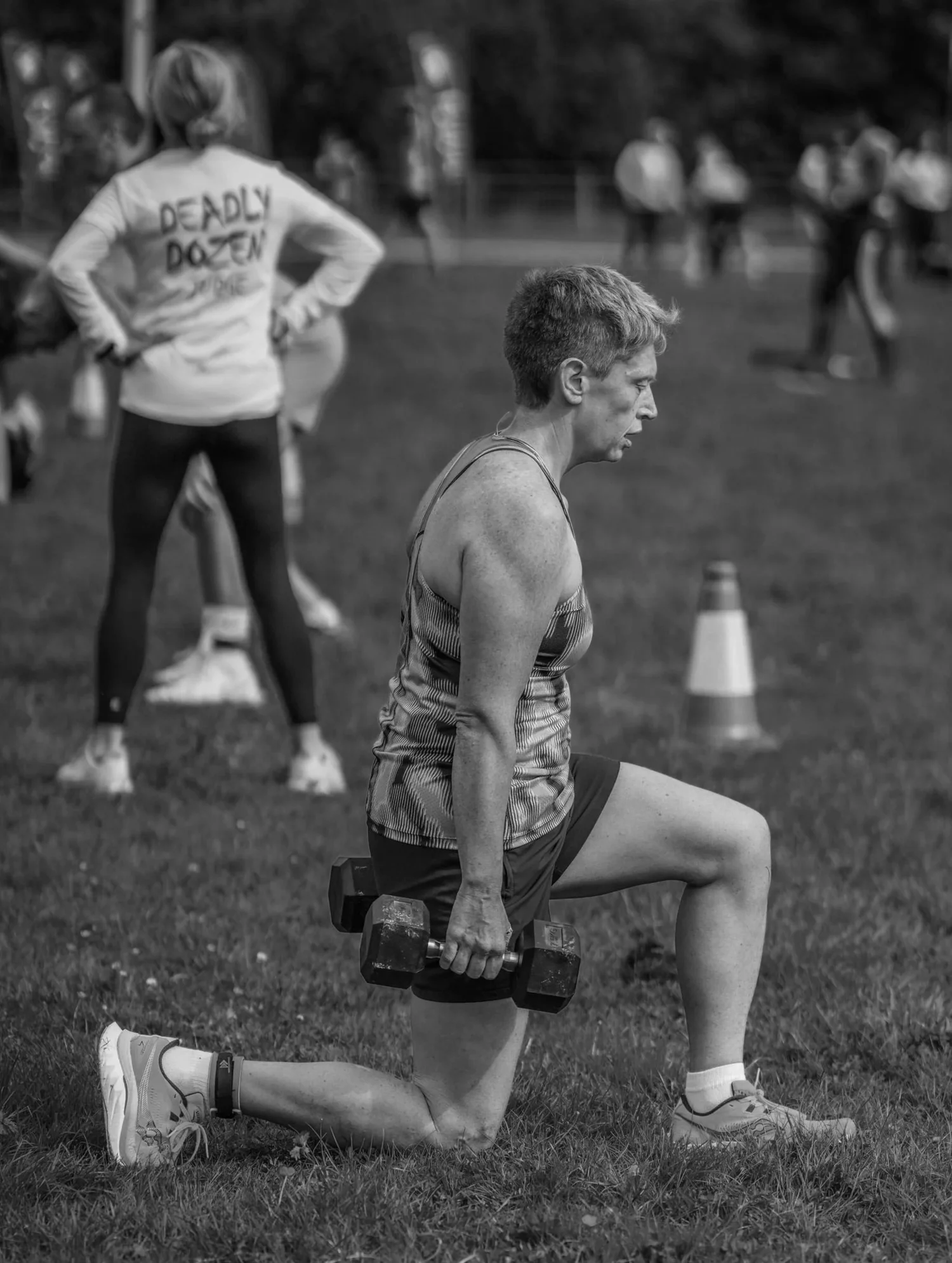 Atleet wat met 'n handgewig loop longe in die Longe Labour doen
