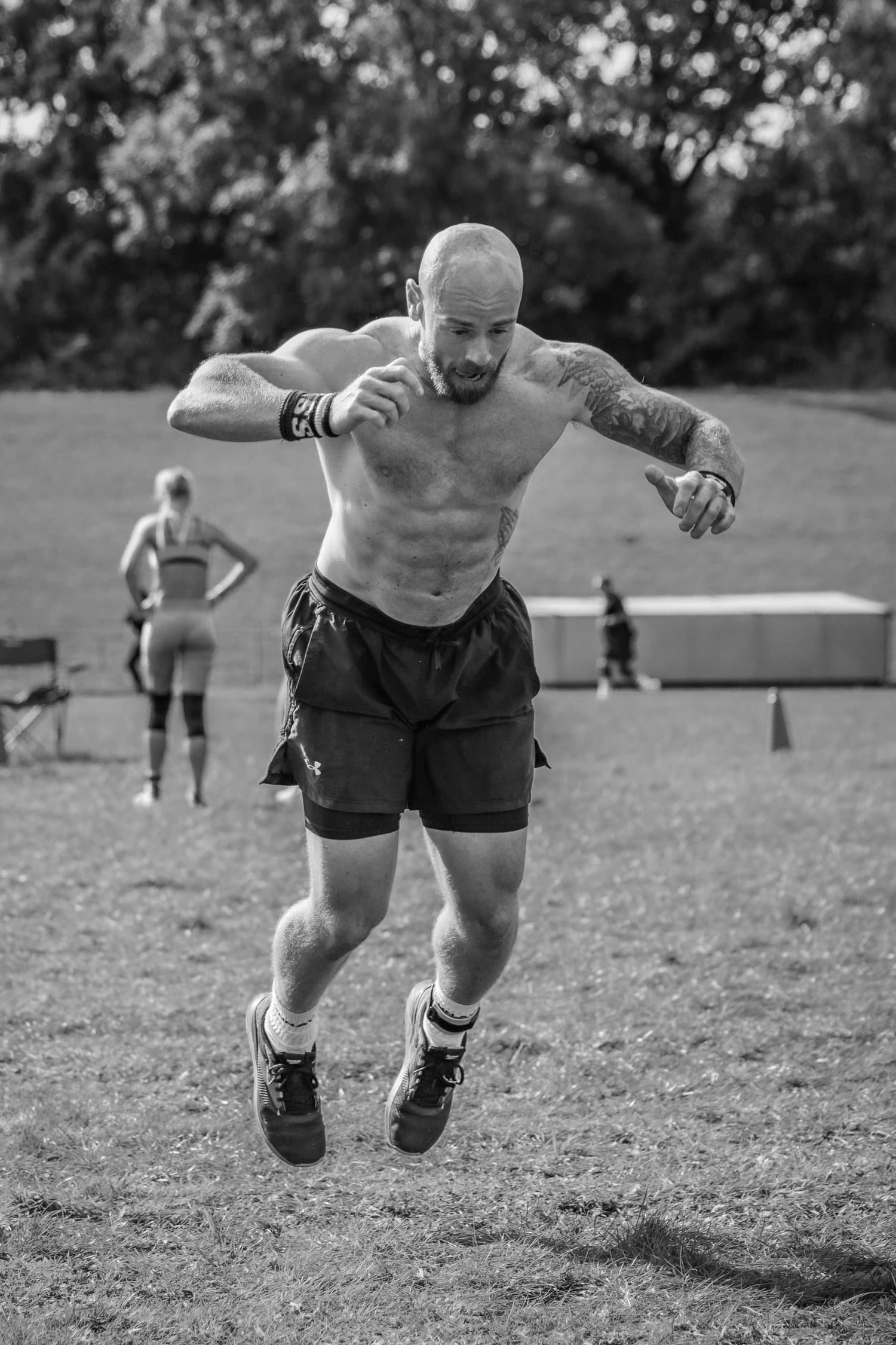 Atleet middel burpee breësprong in die 30m-baan