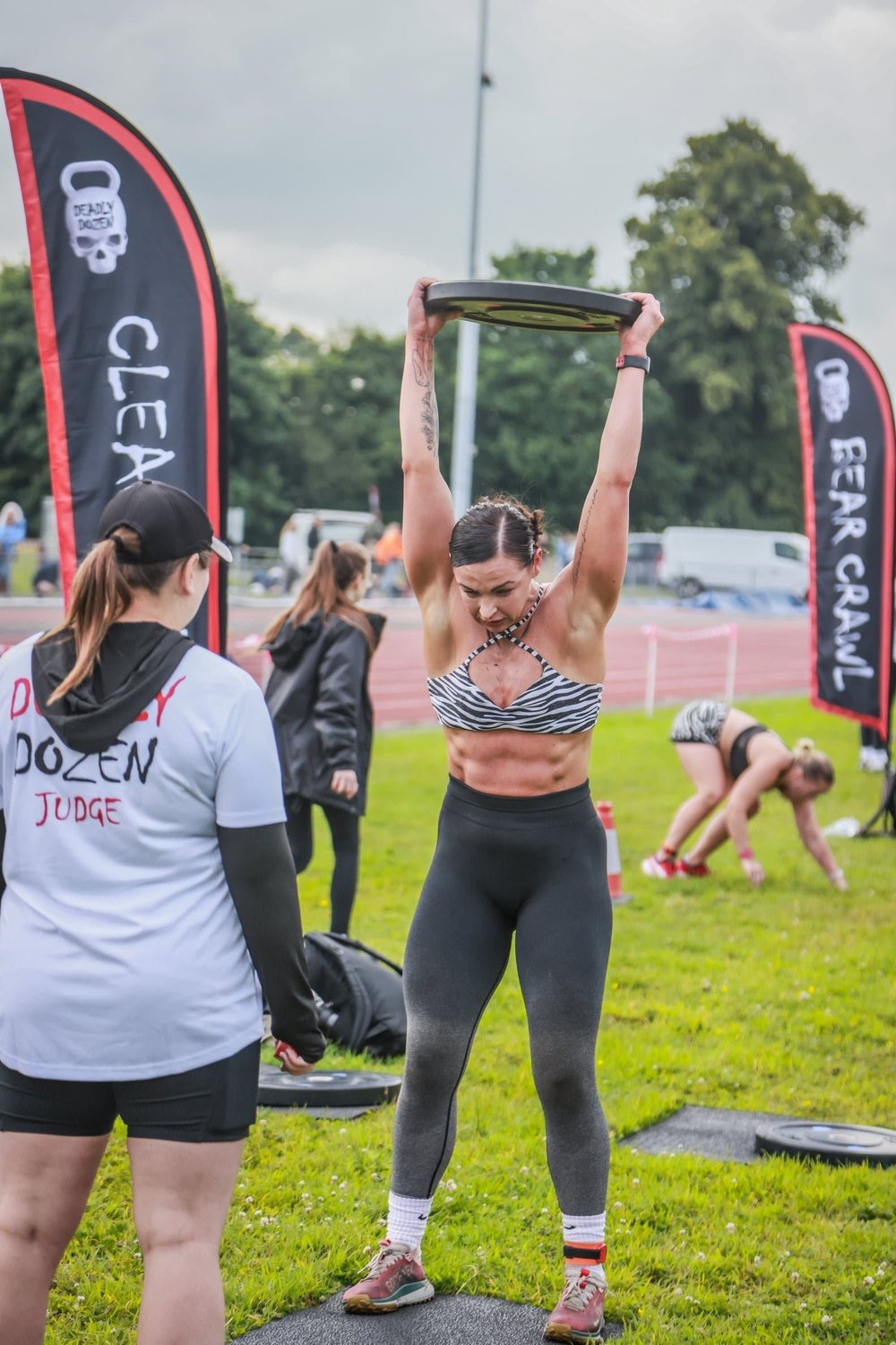 Beoordelaars en atlete op die baan tydens 'n Deadly Dozen-wedrendag